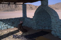 Bedouin man worshipping in Eastern Desert Mosque made with brick and painted turquoise African Middle East North Africa Male Men Guy Religious Male Man Guy Religion One individual Solo Lone Solitary