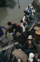 People boarding boat on the River Gambia.African Gambian Western Africa