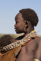 Dombo village  Hamer peoples  Hamer lady with baby in goatskin sling decorated in cowrie shellsJane Sweeney