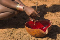 Dombo village  Hamer lady stiring cows blood ready for drinking