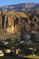 Village at base of cliffs near empty niche where the famous carved Budda once stood  destroyed by the Taliban in 2001