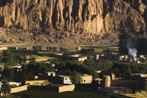 Village at base of cliffs near empty niche where the famous carved Budda once stood  destroyed by the Taliban in 2001