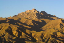 Late afternoon sun glows on mountains near the empty niche where the famous carved Budda once stood  destroyed by the Taliban in 2001