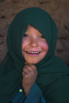 Girl that lives in a cave in the cliffs near empty niche where the famous carved small Budda once stood 180 foot high before being destroyed by the Taliban in 2001