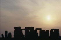 Standing stones on Salisbury Plain silhouetted at sunset with a yellow sky