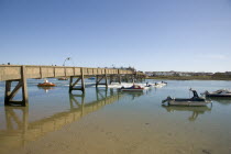 Footbridge across the river Adur with waterskiers passing under.