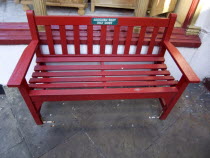 Red wooden bench with a Smokers Rest plaque