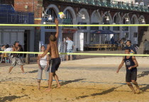 People playin beach volleyball on the seafront outside the Grand Hotel.European Beaches Great Britain Northern Europe Resort Sand Sandy Seaside Shore Tourism UK United Kingdom