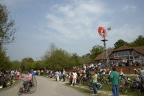 Amberley Working Museum. Veteran Cycle Day Grand Parade. Woman riding a bicycle with visitors watching.