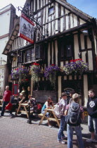 Old Town. George Street . Tmbered frontage of Ye Olde Pump House pub with people sitting outside at tables under hanging baskets