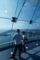 Gunwharf Quay, The Spinnaker Tower. Interior at top of tower on the observation deck with a man and woman looking out of glass windows providing a 320¡ view of the city of Portsmouth  the Langstone a...