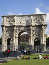 Tourists at the base of the 3rd century Arch of Constantine outside the Forum beside the Colosseum commemorating his victory over his co-emperor Maxentius