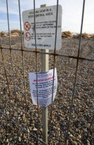 Timber washed up on the beach from the Greek registered Ice Princess which sank off the Dorset coast on 15th January 2008. A sign behind wire fencing warns people to keep off the beach