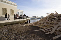 Timber washed up on the beach from the Greek registered Ice Princess which sank off the Dorset coast on 15th January 2008. Sightseers on the Pier look at the debris beside it