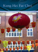 Lion Dance troupe and musicians performing in Wardour Street amongst the crowd outside restaurants during Chinese New Year celebrations in 2006 for the coming Year of The Dog