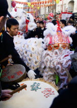 Lion Dance troupe performing in Wardour Street amongst the crowd outside a restaurant during Chinese New Year celebrations in 2006 for the coming Year of The Dog