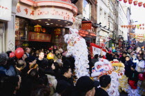 Lion Dance troupe and musicians performing in Wardour Street amongst the crowd outside restaurants during Chinese New Year celebrations in 2006 for the coming Year of The Dog