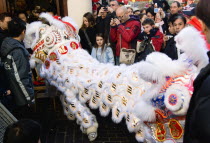 Lion Dance troupe and embroidered banners in Gerrard Street amongst the crowd during Chinese New Year celebrations in 2006 for the coming Year of The Dog