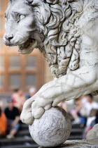 ITALY, Tuscany, Florence, Sculpture of a lion with its paw on a cannon ball at the entrance to the Loggia del Lancia, or Loggia di Orcagna named after the architect in Piazza della Signoria.