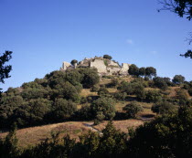 Ruins of Chateau Termes  medieval Cathar stronghold on top of steep  tree covered hillside.