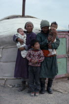 Family standing outside yurt.