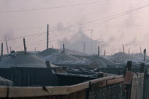 Yurt district with shadowy grey rooftop of the Gandan Monastery behind in winter.