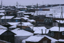 Snow covered rooftops of traditional housing in city suburb in winter.