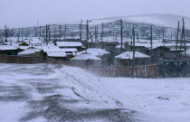 Traditional housing in city suburb in windblown winter snow.