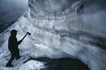 Ice hunter using axe to cut blocks of ice near La Cumbre.