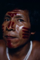 Portrait of Venancio Makuna  sub-group of Tukano  headman Ignacios son  decorated with red ochote facial paint for dance/manioc ceremony