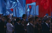 Nadam  National Day Parade of workers and party members carrying red and blue banners  the two prime national colours. Ulaan Baatar  Soviet Mongolia East Asia Asian Baator Male Man Guy Mongol Uls Mon...