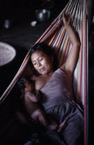 Makuna mother  Venancios wife  breastfeeding baby lying in hammock.Tukano  Makuna Indian North Western Amazonia family American Babies Colombian Columbia Hispanic Indegent Kids Latin America Latino M...