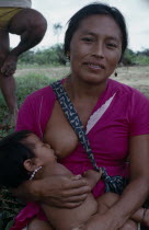 Makuna mother breastfeeding baby.Tukano  Makuna Indian North Western Amazonia family American Babies Colombian Columbia Hispanic Indegent Kids Latin America Latino Mum South America Tukano