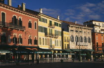 Piazza Bra.  Line of empty bars and cafes and painted facades of architecture overlooking square.