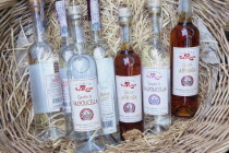 Bardolino.  Selection of bottles of grappa displayed in basket.