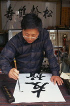 Caligrapher at work in Hutong workshop.