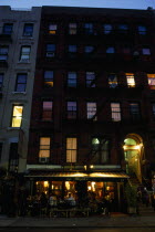 East Village. Cafe Mogador with tables and chairs under awning and apartments above