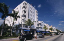 South Beach. Ocean Drive. Art Deco Park Central Hotel  exterior lined with palm trees and cars parked outside