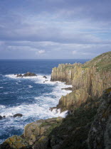 Waves breaking against eroded sea cliffs in winter.