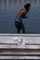 Sikh man washing himself whilst wearing kachs.