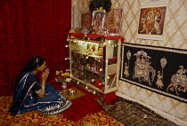 England.  Girl at prayer at home during Dirwali.