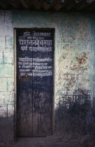 Narrow wooden temple door with painted inscription