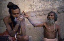 Sadhus lighting and smoking chillum