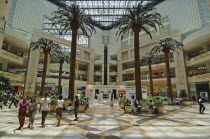 Interior of a shopping centre with palm trees.