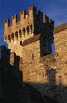 Sirmione.  Rocca Scaligera medieval castle  detail of fortified tower and crenellated walls with visitor looking out from tower top.