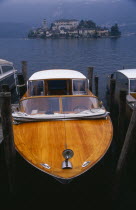 Moored boat taxi with small island densely covered with buildings behind.