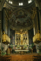 Salo.  Interior of the Duomo with ornate golden altarpiece  crucifix and painted walls and vaulted ceiling.