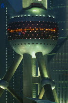 Part view of the Oriental Pearl Tower exterior illuminated at night.