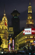 Nanjing Lu.  Looking towards Renmin Square or the People s Square at night with illuminated buildings and neon signs.  Crowds in foreground  radio tower behind.