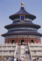 Tiantan Park.  The Hall of prayer for Good Harvests   qi nian dian  .  Tiered  highly decorated exterior with visitors on steps in foreground.